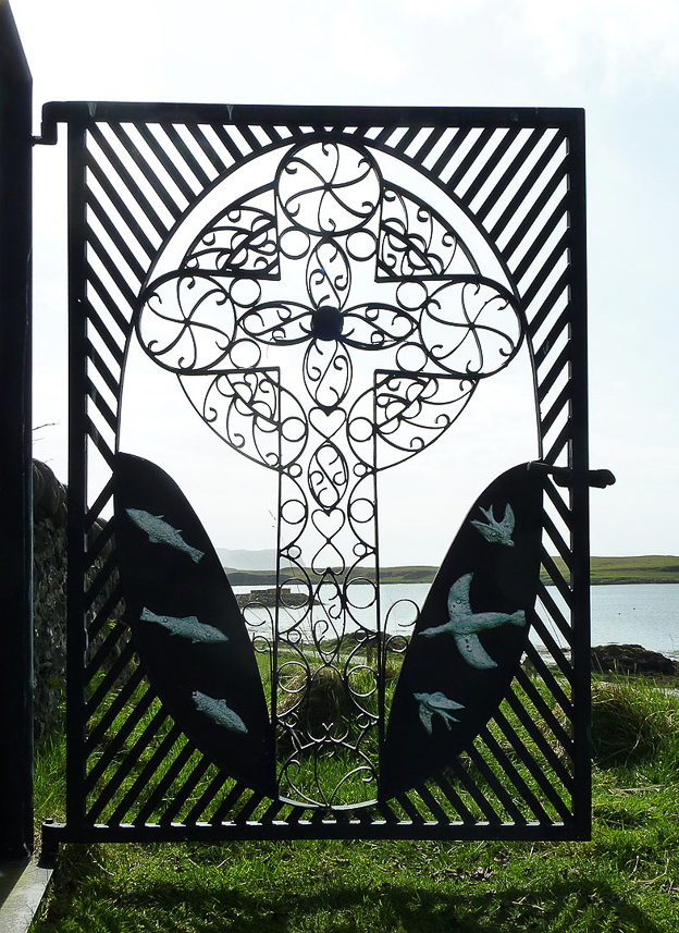 The Celtic cross on the iron gate to the graveyard