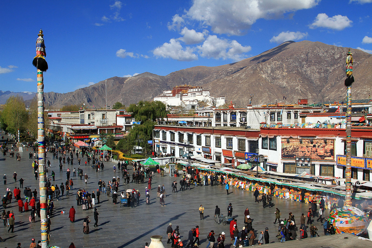 View from Johkang temple over the Barkhor square with Potala in the background. Two Dhavjas (Victory banner poles) are seen on the square.