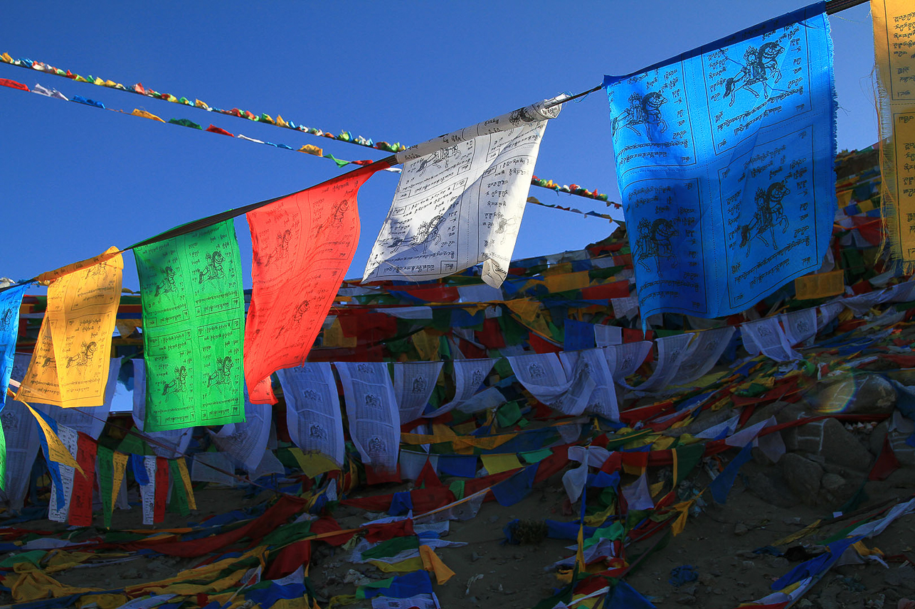 Prayer flags, used to bless the countryside and to promote peace, compassion, strength, and wisdom. The colours represent the elements, e.g. blue =  sky/space, white = air/wind, red = fire, green = water and yellow = earth.