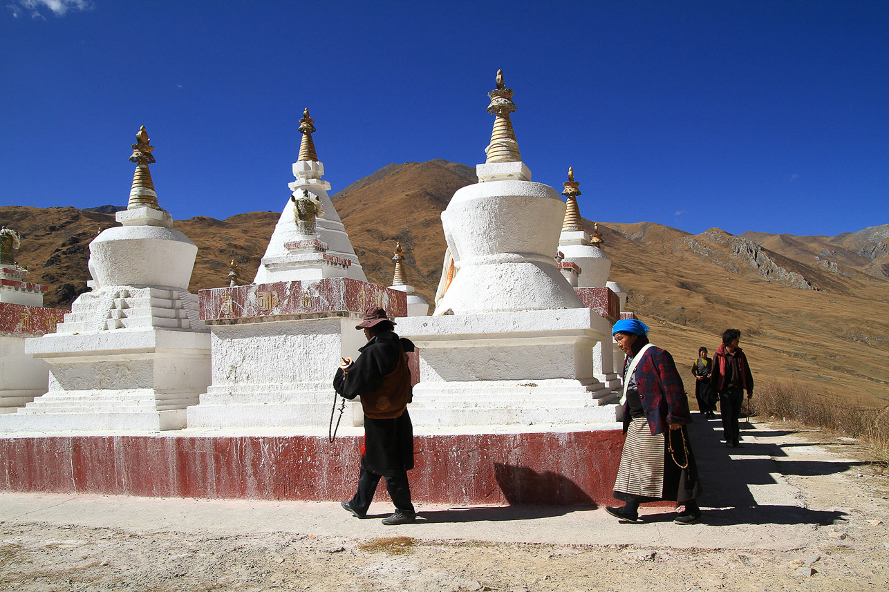 Stupa close to Drak Yerpa, people performing a small kora  (walking clockwise, circumambulatin, around the stupa and praying).