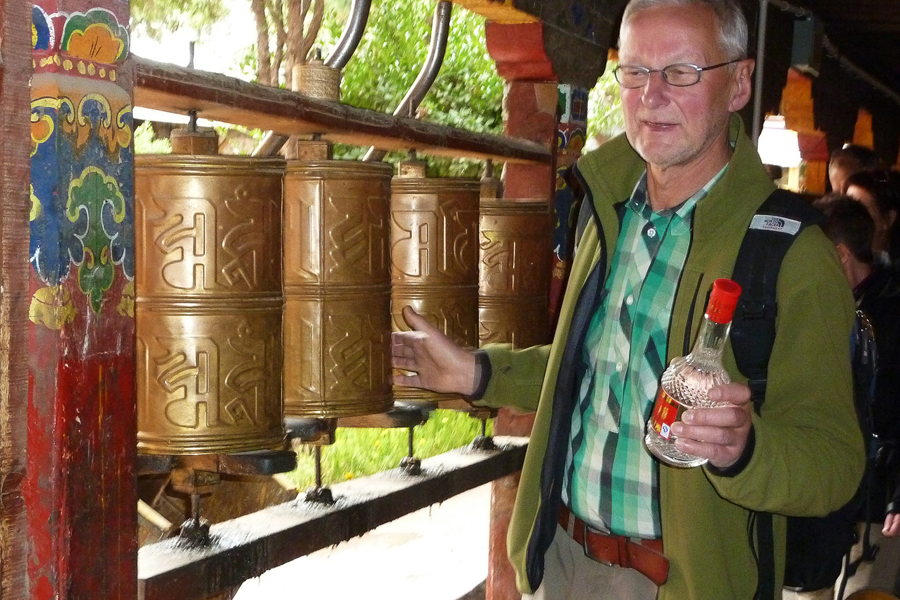 Bengt rolling the prayer wheels, just going to sacrifice a bottle of liquor in a small monastery.