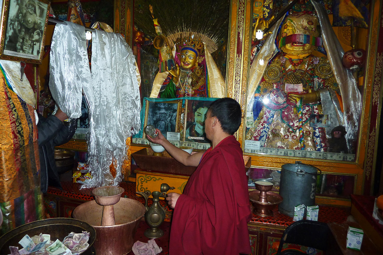 The monk pours the liquor out while performing prayers.