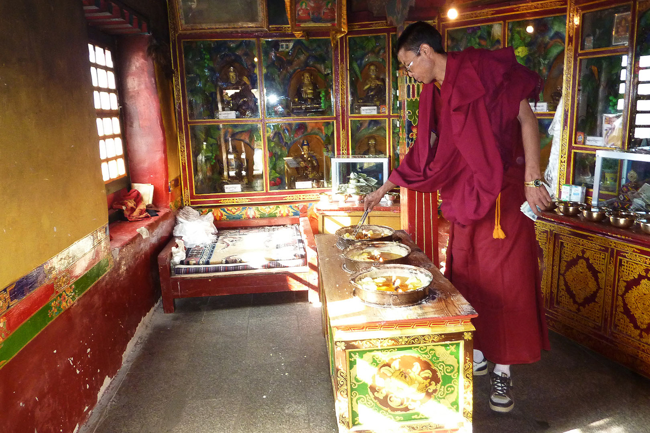 Inside Drak Yerpa monastery, handling the wax candles.