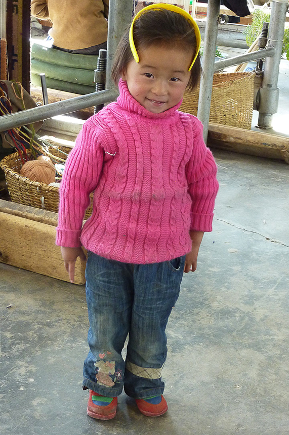 Child following her mother at the carpet factory.