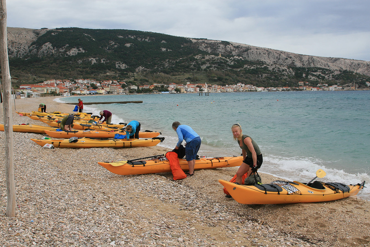 The shore at Baska, with a camping site.