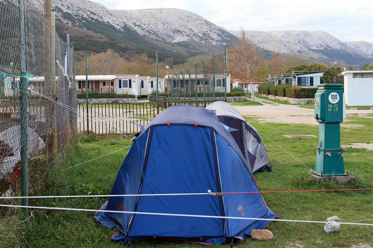 Seeking shelters for the tent in the hard wind.